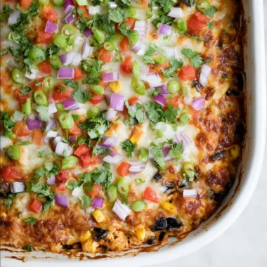 Delicious Chicken Burrito Casserole topped with melted cheese and fresh ingredients