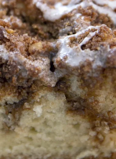 Delicious homemade coffee cake on a plate with a steaming cup of coffee