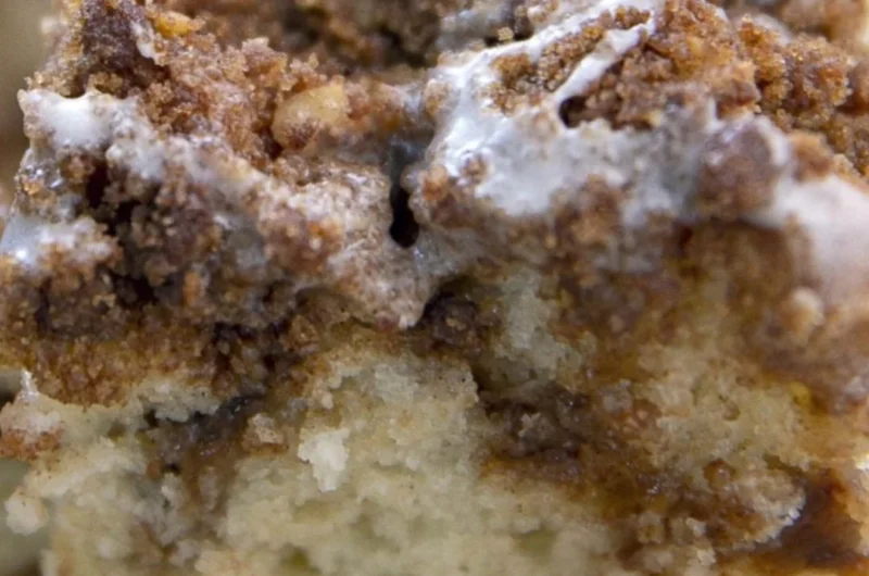 Delicious homemade coffee cake on a plate with a steaming cup of coffee