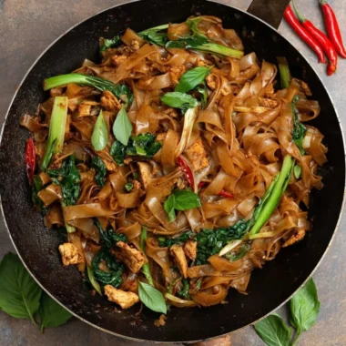 Plate of delicious drunken noodles with vegetables and spices