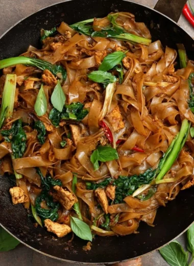 Plate of delicious drunken noodles with vegetables and spices