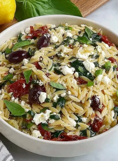 Orzo pasta salad with feta cheese and sun-dried tomatoes in a bowl