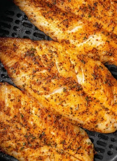 Crispy air fryer tilapia fillet served with lemon and herbs