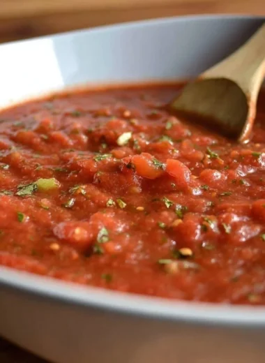 Authentic San Marzano pizza sauce in a glass jar with fresh tomatoes.