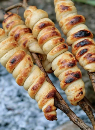Homemade Campfire Bread cooking over an open flame outdoors