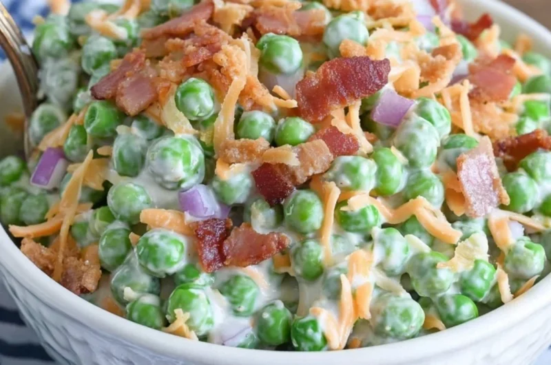 Classic pea salad with bacon served in a bowl, garnished with herbs.
