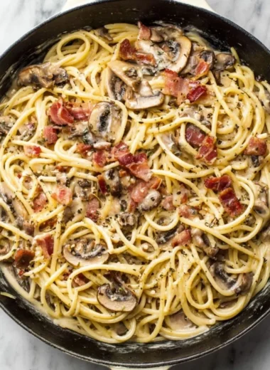 Creamy bacon mushroom pasta dish garnished with parsley on a plate