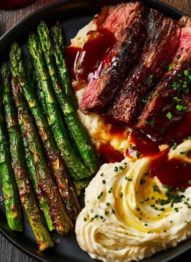 Delicious gourmet steak served with mashed potatoes and asparagus on a plate.