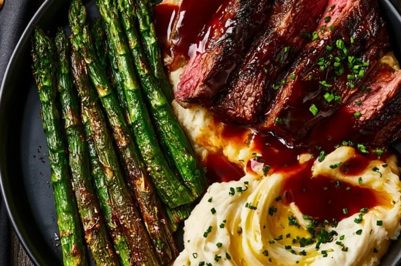 Delicious gourmet steak served with mashed potatoes and asparagus on a plate.