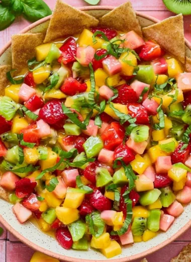 Fresh fruit salsa served with cinnamon sugar chips on a colorful plate.
