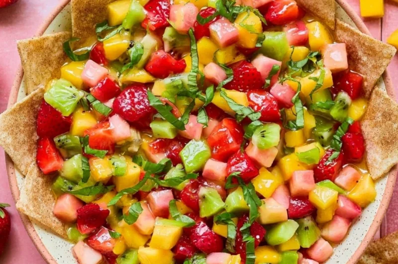 Fresh fruit salsa served with cinnamon sugar chips on a colorful plate.