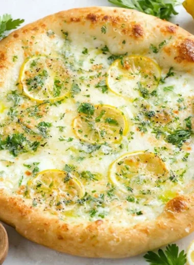 Delicious lemon pizza topped with fresh herbs and cheese