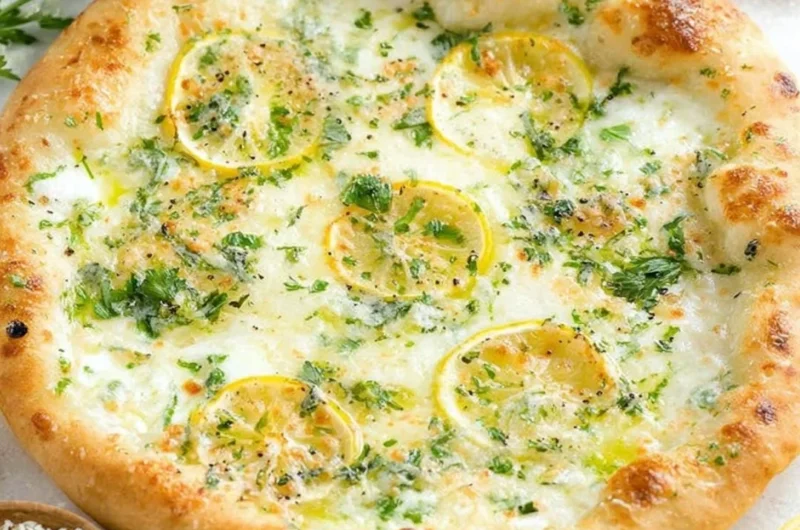 Delicious lemon pizza topped with fresh herbs and cheese