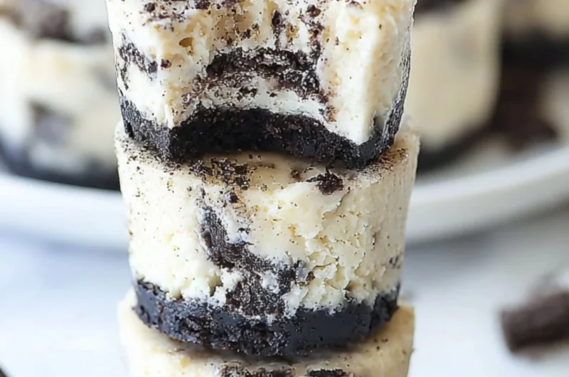 Mini Oreo Cheesecakes topped with crushed Oreos on a cookie crust.