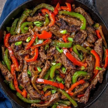A colorful pepper steak stir fry served in a skillet with vibrant vegetables.