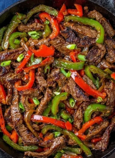 A colorful pepper steak stir fry served in a skillet with vibrant vegetables.