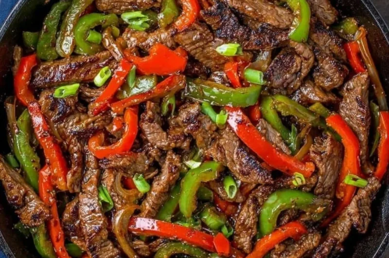 A colorful pepper steak stir fry served in a skillet with vibrant vegetables.