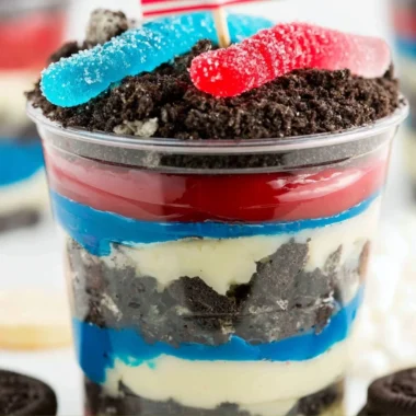 Red, White, and Blue Dirt Cups dessert in clear cups with layers of cookies and cream