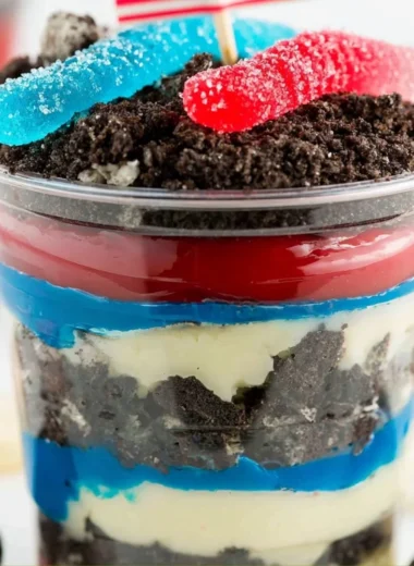 Red, White, and Blue Dirt Cups dessert in clear cups with layers of cookies and cream