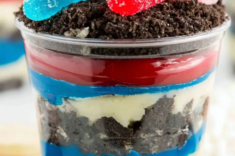 Red, White, and Blue Dirt Cups dessert in clear cups with layers of cookies and cream