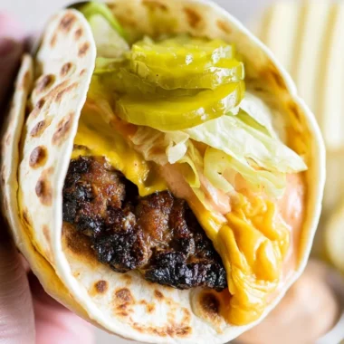 Smash Burger Taco topped with flavorful burger sauce and fresh toppings