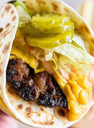 Smash Burger Taco topped with flavorful burger sauce and fresh toppings