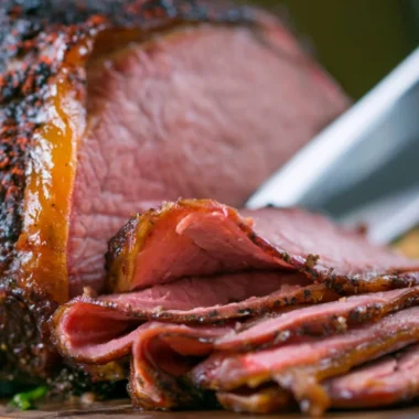 Deliciously smoked roast beef served on a wooden cutting board.