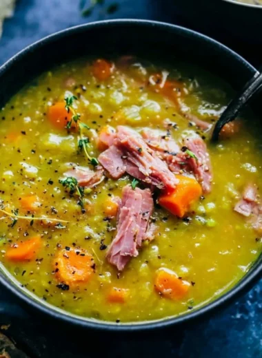 Bowl of homemade Split Pea Soup garnished with herbs and served with bread.