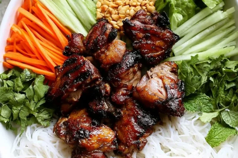 Delicious Vietnamese grilled pork rice noodle bowl garnished with fresh herbs.