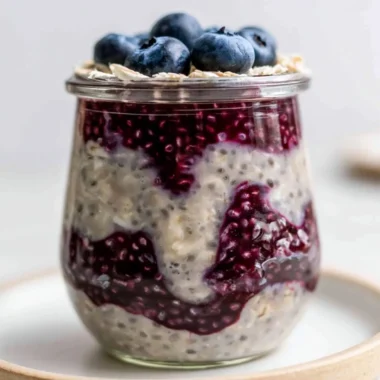 Bowl of blueberry overnight oats topped with fresh blueberries and nuts