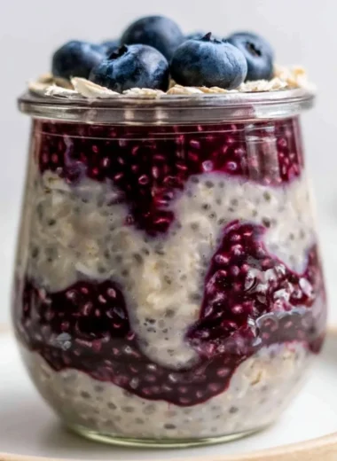 Bowl of blueberry overnight oats topped with fresh blueberries and nuts