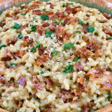 Creamy Carbonara Risotto garnished with bacon and parsley in a plate