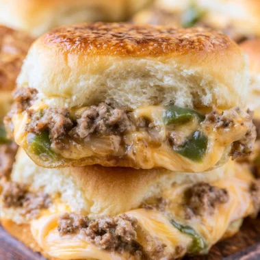 Delicious Philly cheesesteak sliders with beef, cheese, and toppings served on rolls.