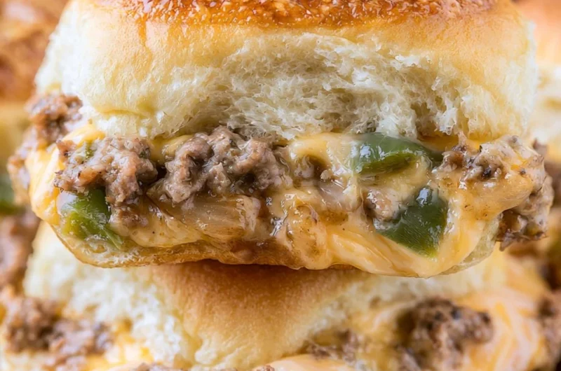 Delicious Philly cheesesteak sliders with beef, cheese, and toppings served on rolls.