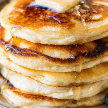 Delicious stack of homemade ricotta pancakes topped with fresh berries and syrup