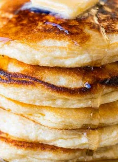 Delicious stack of homemade ricotta pancakes topped with fresh berries and syrup