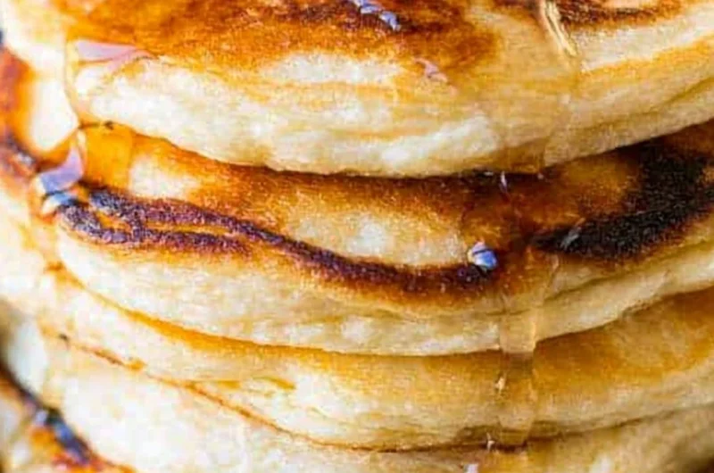 Delicious stack of homemade ricotta pancakes topped with fresh berries and syrup