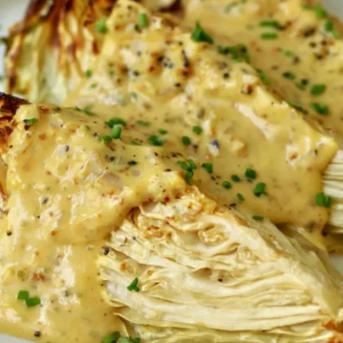 Roasted cabbage wedges with onion-Dijon sauce on a plate