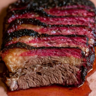 Smoked beef chuck roast on a cutting board garnished with herbs