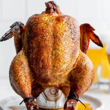 Delicious smoked beer can chicken on a grill, showcasing crispy skin and juicy meat.