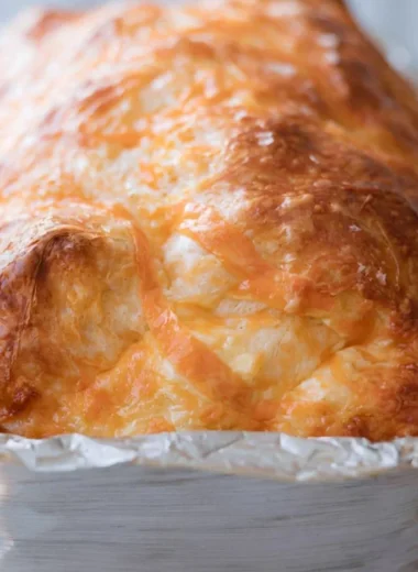 Freshly baked sourdough cheese bread with a golden crust and gooey cheese inside.