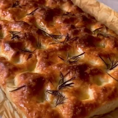 Delicious homemade sourdough focaccia bread topped with herbs and olive oil.