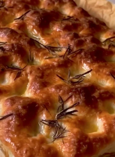 Delicious homemade sourdough focaccia bread topped with herbs and olive oil.
