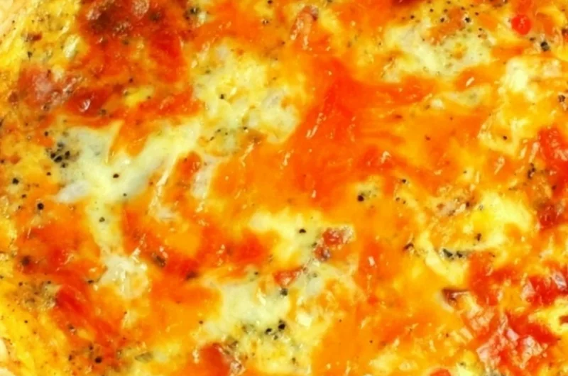 Delicious easy bacon cheese quiche sliced on a wooden board